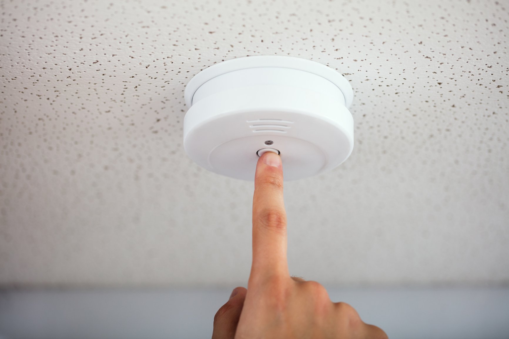 Person Testing Smoke Detector